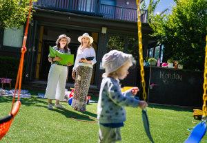 2 educators and a child in outdoor space