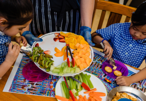 2 children eating fruit and vegetables