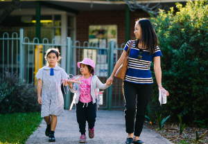 Parent walking 2 children into a service