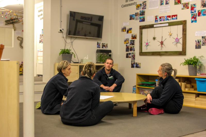 educators sitting on the floor and talking to each other