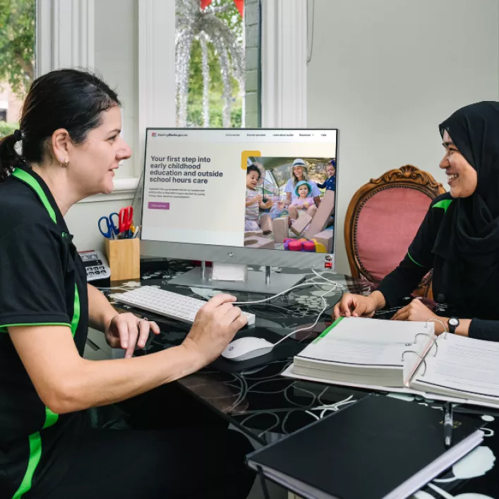 Two educators with computer screen