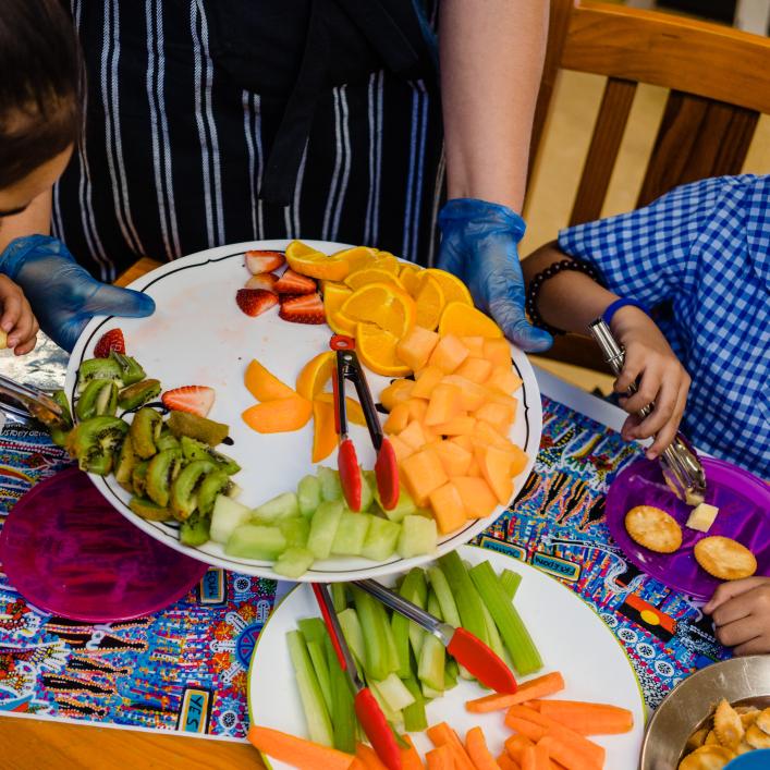 2 children eating fruit and vegetables