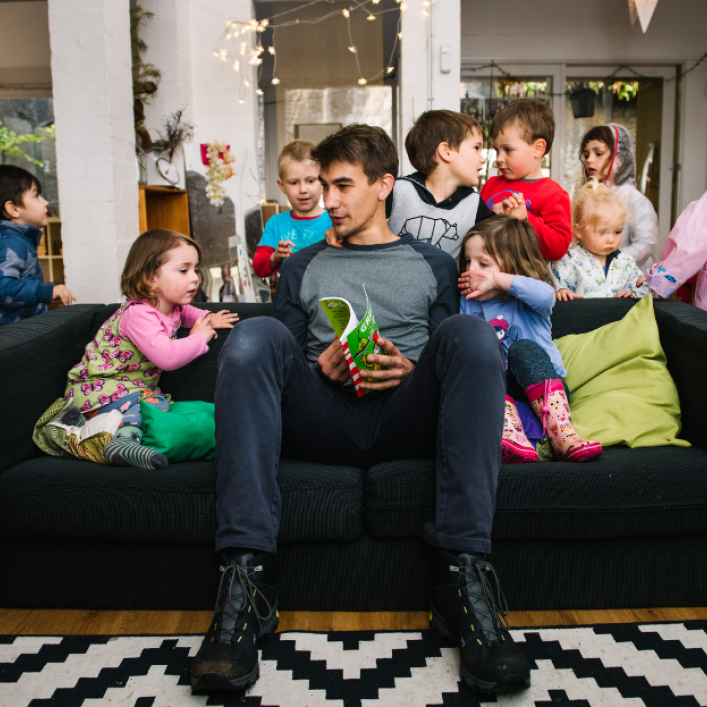 Adult sat on sofa with children