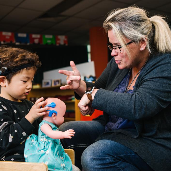 Educator speaking sign language with child