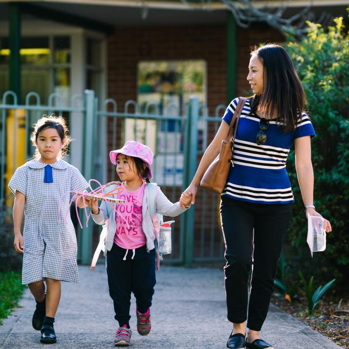 Parent walking 2 children into a service