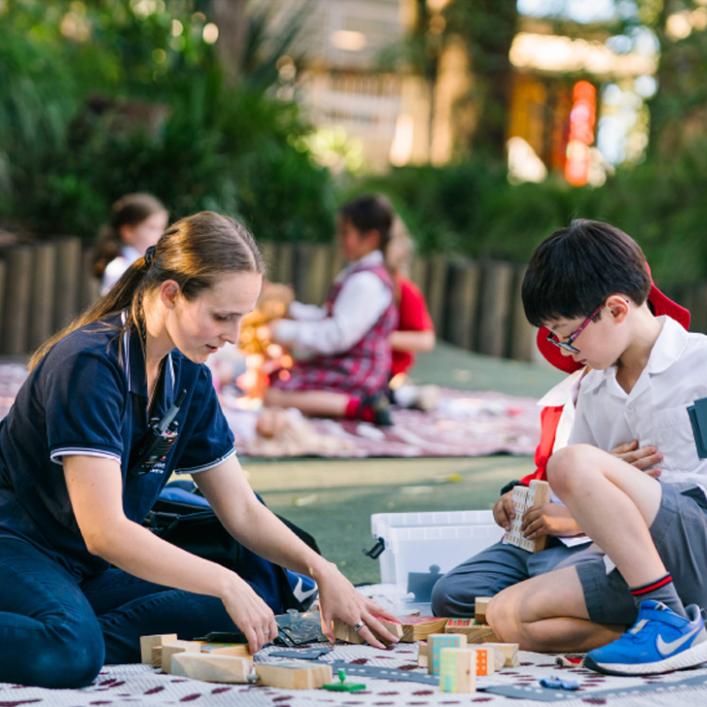 NQF Snapshot Q2 2024 cover image of an educator sitting in an OSHC setting with children